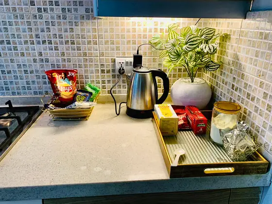 Welcome tray. Electric kettle with tea, snacks and crockery set out on the counter.