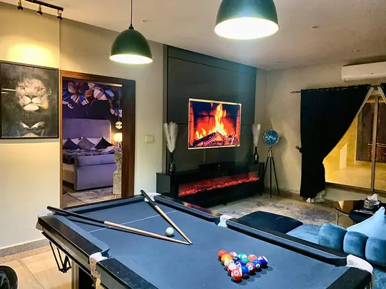 Lounge view across the pool table to the fireplace and balcony.