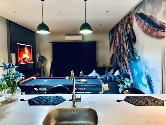 Breakfast-bar view over the pool table and feather mural.