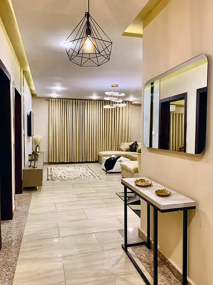 Entrance hallway with console table, mirror and a geometric pendant light.