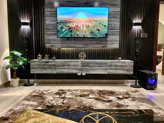 TV wall with slate-look panel, wall washers, speakers, subwoofer and floating console.