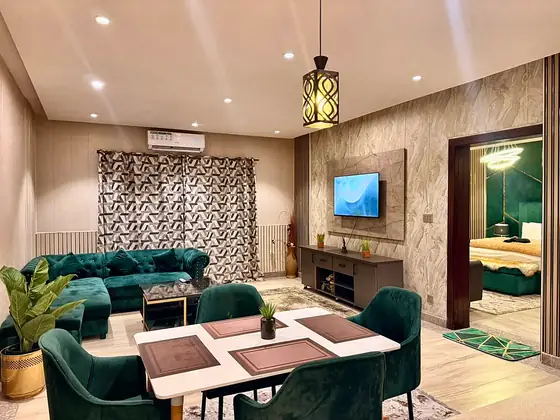 Lounge and dining with the bedroom visible through the door; pendant lamp and split AC.