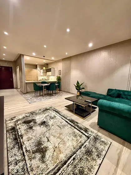 Lounge floor plan view with emerald sofa and printed rug.