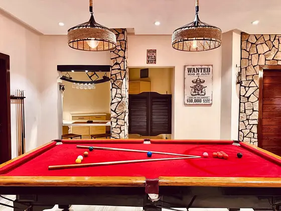Pool table with cues and balls beside the saloon-style doors.