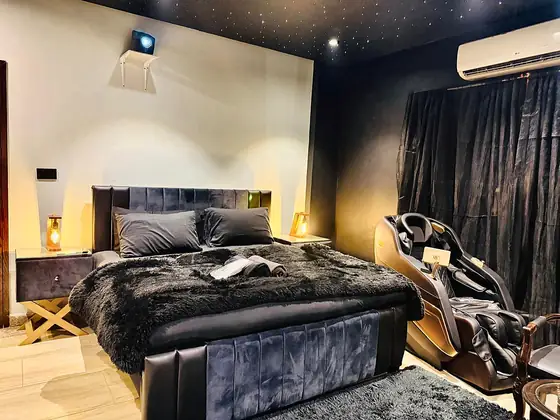 Bedroom with a starry fibre-optic ceiling, projector and full-body massage chair.