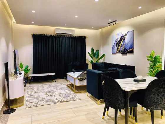 Living room overview with black curtains, TV and abstract art.