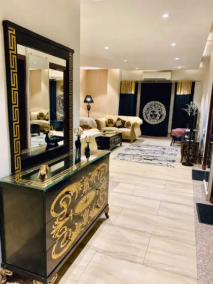 Hallway with a gilded black dresser and mirror.